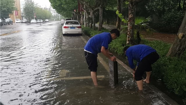 商水城管雨中疏通道路排水口