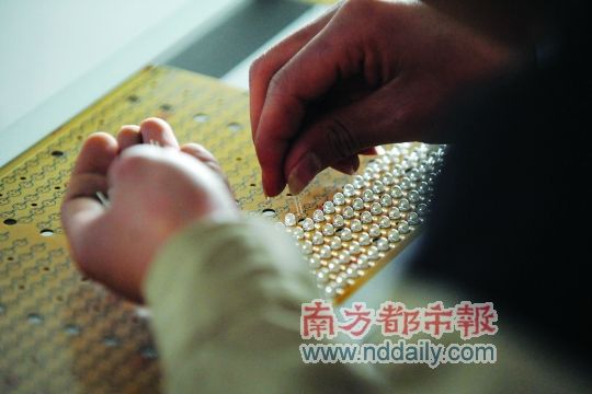 工人忙著安裝用于燈具發(fā)光的LED燈珠，這類工作處于LED燈具生產(chǎn)的最下游。資料圖